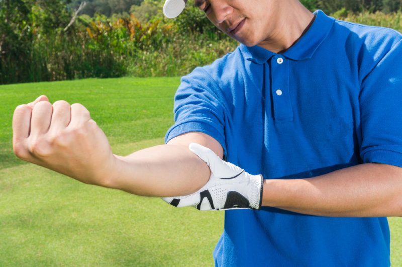 Douleur au coude du golfeur pendant le jeu, concept de blessure musculaire.